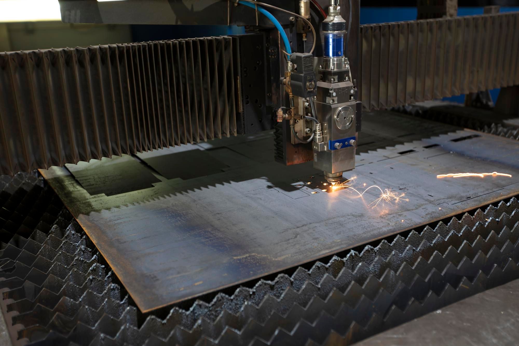 Corte láser de chapa metálica con chispas en máquina industrial CNC