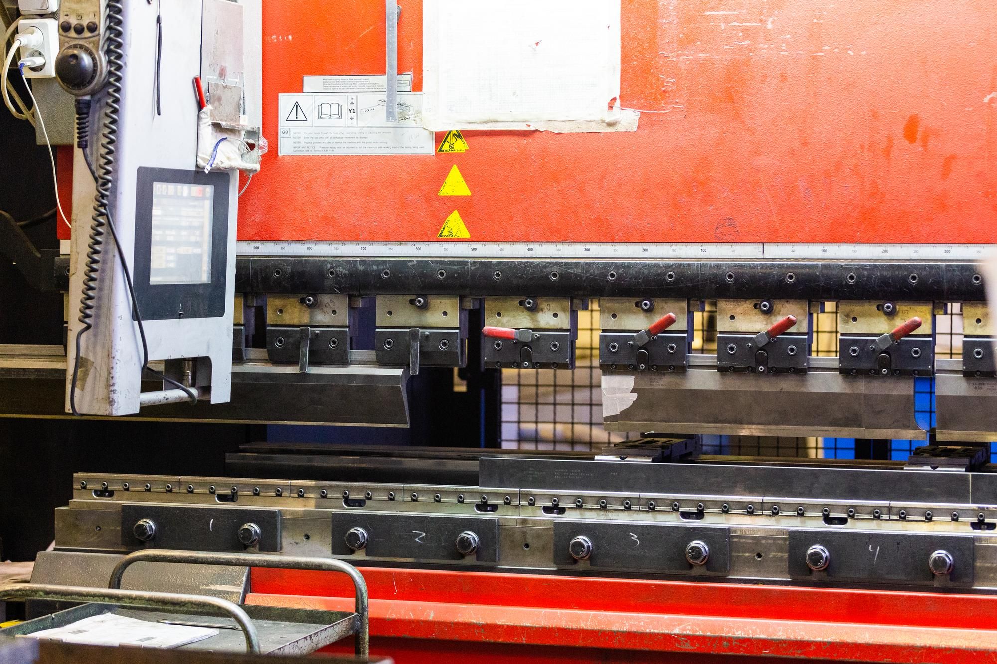 Detalle de prensa plegadora hidráulica industrial con protección de seguridad láser