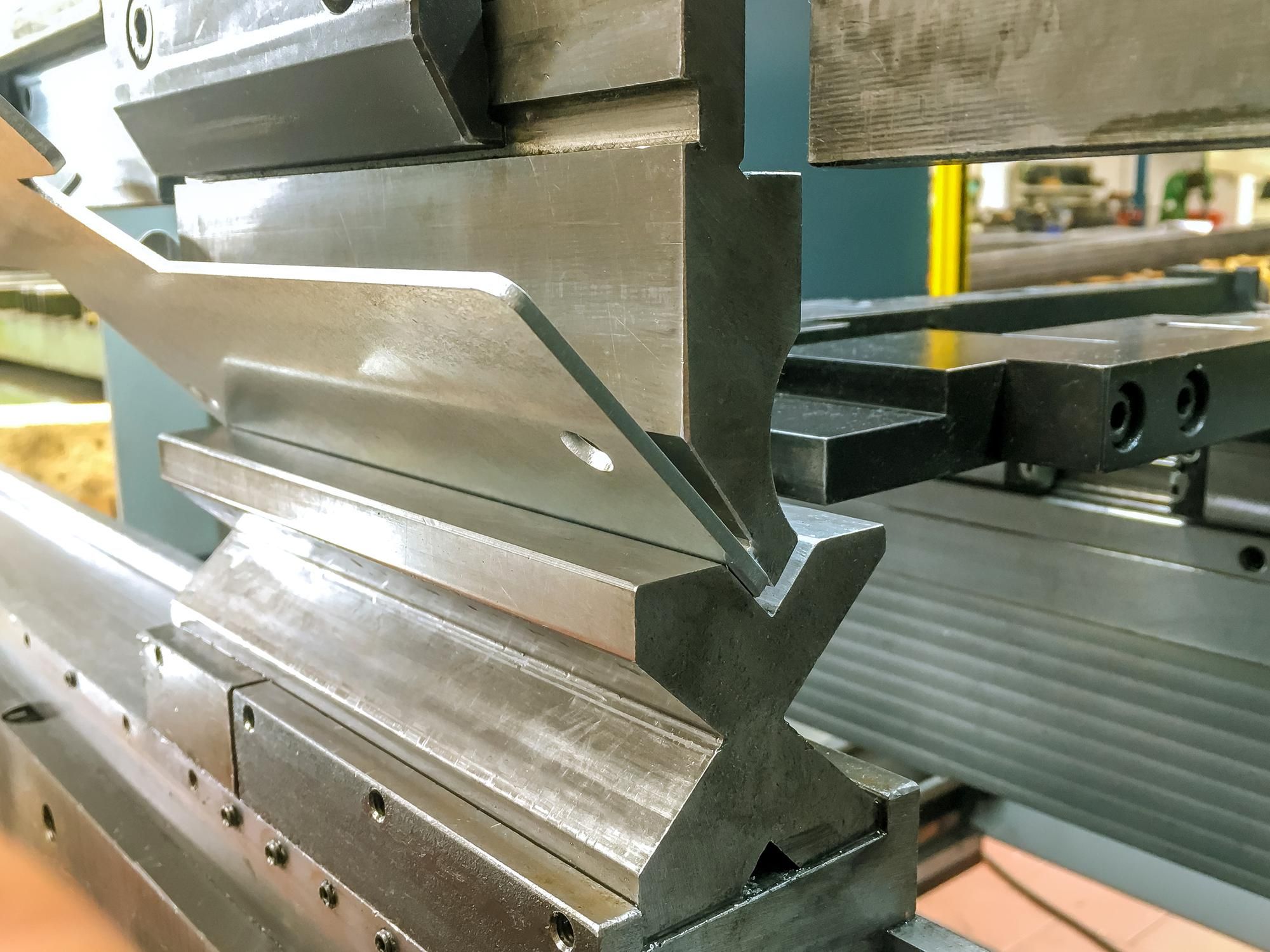 Doblado de chapa metálica con máquina hidráulica en planta de fabricación